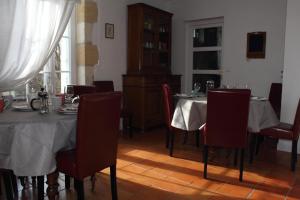 a dining room with two tables with red chairs at Relais de la Renaissance in Saint-Michel-de-Montaigne