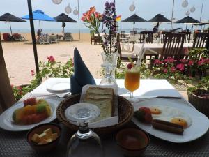 a table with a plate of food on the beach at The Villa Hotel in Unawatuna