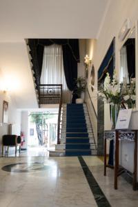 a lobby with a staircase with blue and white walls at Hotel Navy in Livorno