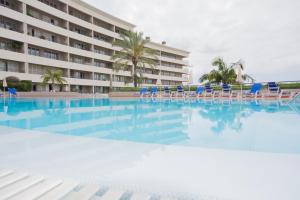 una piscina con sillas y un hotel en M Palace II en Funchal