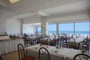 a banquet room with tables and chairs with a view of the ocean at Hotel Kent in Riccione
