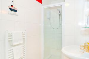 a white bathroom with a shower and a sink at The Lagg in Lagg