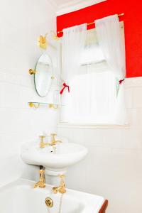 a white bathroom with a sink and a mirror at The Lagg in Lagg