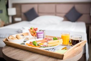 ein Tablett mit Essen auf einem Tisch in einem Schlafzimmer in der Unterkunft Meet Poznań Hotel in Posen