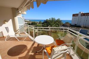 un balcón con una mesa y sillas blancas y el océano en Apartamento Bellavista, en Miami Platja