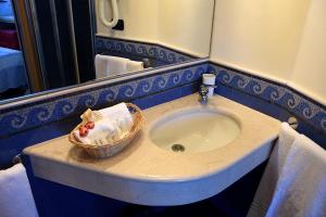 ein Bad mit einem Waschbecken und einem Korb darauf in der Unterkunft Villa Nina in La Spezia
