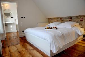 Una cama blanca con una bandeja de comida. en Guesthouse Bernardin en Amberes