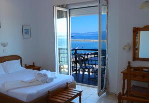 a bedroom with a bed and a view of the ocean at Akti Hotel in Limenas