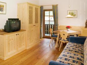 a living room with a television and a dining room table at Plonerhof in Lagundo