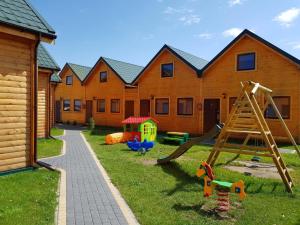 un patio con parque infantil con tobogán en Ferienhäuser Eurobaltyk, en Rewal