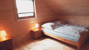 Un dormitorio con una cama en una cabaña de troncos en Ferienhäuser Eurobaltyk, en Rewal