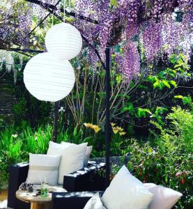 SaussignacにあるAux Champésの紫の花とテーブルと傘が飾られた庭園