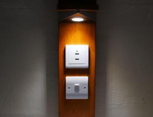 a light on a wooden wall with a light on it at Elterwater Hostel in Elterwater