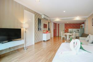 - un salon avec deux cygnes assis sur un lit dans l'établissement My Resort Hua Hin B111, à Hua Hin