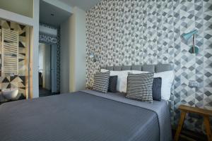 sypialnia z niebieskim łóżkiem i ścianą w obiekcie 15 Quindici by Serendipity Rooms w Mediolanie