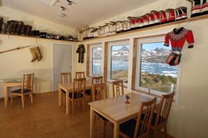 a dining room with a table and chairs and a window at The Red House in Tasiilaq