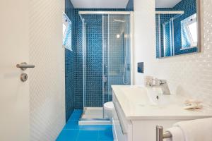 bagno con lavandino e doccia con piastrelle blu di Apartment Guarda-Mor a Lisbona