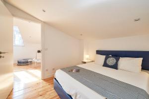 una camera con un grande letto con testiera blu di Apartment Guarda-Mor a Lisbona