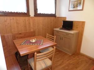 a kitchen with a wooden table with a laptop on it at Appartamenti Nigritella in Falcade
