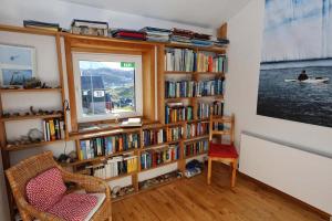 una sala de estar con una estantería llena de libros en The Red House en Tasiilaq