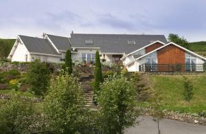 une maison sur une colline avec un jardin dans l'établissement Wicklow Way Lodge, à Wicklow