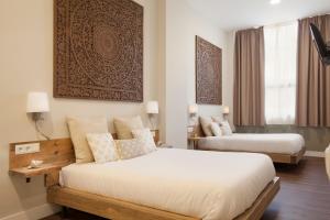 una camera d'albergo con due letti e un divano di Hotel Radha a Hospitalet de Llobregat