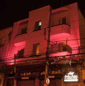 un edificio con una luz rosa proyectada en él en Hotel Jardim América ( Adults only), en São Paulo