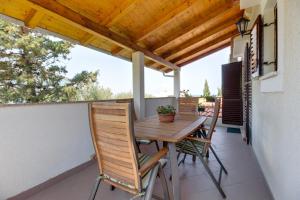 a balcony with a wooden table and chairs at Argo Apartmani in Mali Lošinj