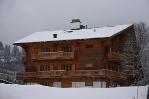 a large wooden house with a snow covered roof at Celine 9, Champery in Champéry
