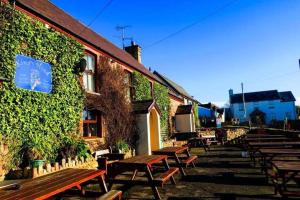 a group of benches sitting outside of a building at King's Head Inn in Llangennith