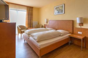 a bedroom with a large bed and a television at Gasthof Siller in Spiegelberg