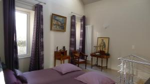 a bedroom with a bed and a desk and a window at La Berlue Bayeux in Saint-Vigor-le-Grand