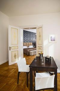 a room with a table and white chairs and a bed at Deminka Palace in Prague