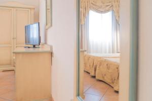 a bedroom with a bed and a television at Hotel Terranova in Olbia
