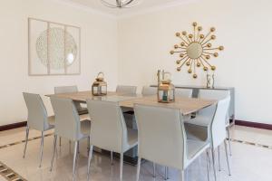 a dining room with a table and chairs at Charming 6BR Villa with Private Pool on Palm Jumeirah in Dubai