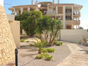 a house with palm trees in front of it at Sierra Cortina Resort in Finestrat