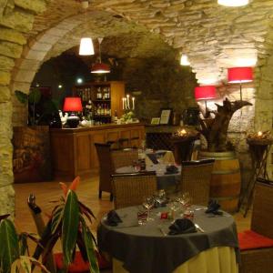 a dining room with a table and a bar at Chateau de Bournet in Grospierres