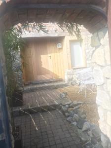 - une entrée pour un bâtiment en pierre avec une porte en bois dans l'établissement Au Bien-Etre D’Elise - Chambre d’hôte, à Fayat