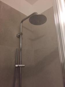 カンヌにあるNapoleonのシャワーヘッド付きのガラスドアが備わるシャワールームです。