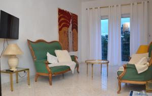 salon z krzesłami, stołem i oknami w obiekcie Les Grands Cedres w Nicei