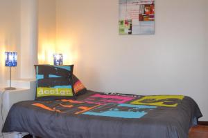 a bedroom with a bed with a colorful comforter at Ribeira Brava Studio Sea View in Ribeira Brava