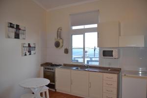 リベイラ・ブラーヴァにあるRibeira Brava Studio Sea Viewのキッチン(シンク、コンロ付)、窓が備わります。