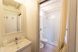 bagno con lavandino, servizi igienici e specchio di Academia Resort a Bergamo