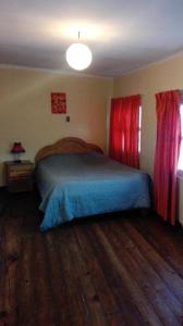 a bedroom with a bed and red curtains at Hostal Isidoros in La Paz