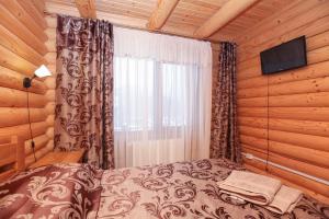 una camera con letto e televisore in una cabina di Cottage Goyra a Jaremče