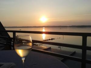 グリュックスブルクにあるFerienwohnung Strandkiekerの夕日を眺めながらテーブルに座るワイン