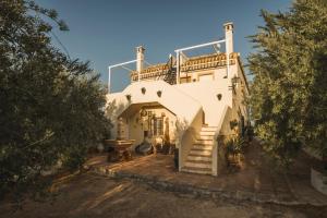 Casa blanca con balcón en la parte superior. en Agroturismo Ecologico el Cortijillo en Luque