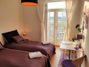 a bedroom with two beds and a table and a window at Roskilde B&B in Gadstrup