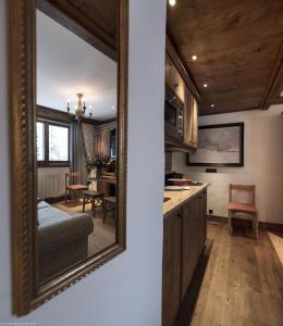 un miroir reflétant une cuisine avec une salle à manger dans l'établissement Appartement 35m² Domaine du Jardin Alpin, à Courchevel