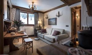 un soggiorno con divano e tavolo di Appartement 35m² Domaine du Jardin Alpin a Courchevel